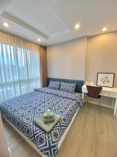 a bedroom with a bed and a desk with a computer at Lucky Room in Ban Bang Saen (1)