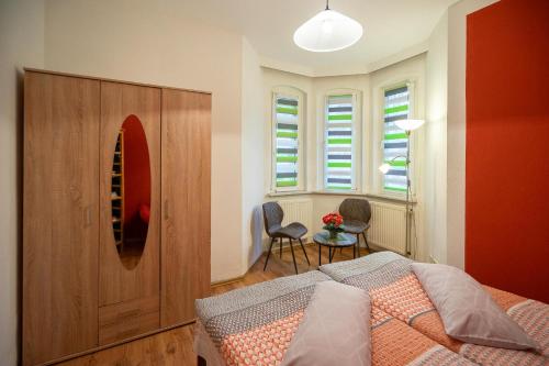 a bedroom with a bed and a wooden cabinet at Ferienwohnung Romy in Naumburg