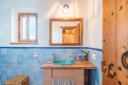 セス・コヴェテスにあるSon Covesの青いタイル張りのバスルーム(シンク、鏡付)