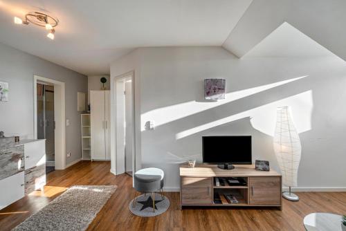 a living room with a tv on a white wall at Ferienwohnung Hobmaier in Forstern
