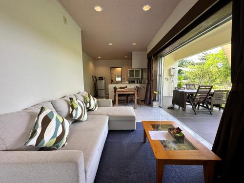 a living room with a couch and a table at Arimabaru Beach Resort in Motobu