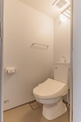 a bathroom with a white toilet in a room at ヴィラポート前島 in Naha