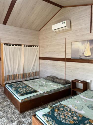 two beds sitting in a room with a wall at Peaceful Hill Homestay in Ke Ga