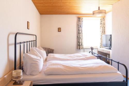 a bedroom with two beds with white sheets and a window at Golf Hotel Des Alpes in Samedan