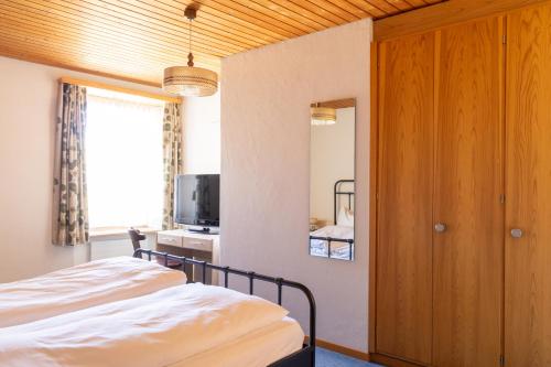 a bedroom with a bed and a tv and a window at Golf Hotel Des Alpes in Samedan