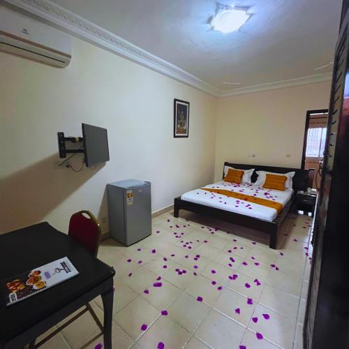 a bedroom with a bed and a table and a room with at Cypa Hotel in Abidjan