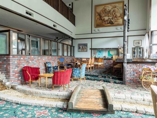 a room with chairs and tables and a brick wall at Sasara in Gero