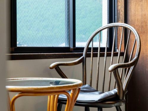 a wooden chair sitting in front of a window at Sasara in Gero