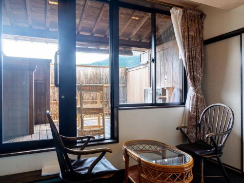 a room with two chairs and a table and a window at Sasara in Gero