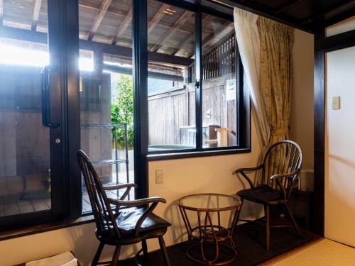 two chairs and a table in a room with a window at Sasara in Gero