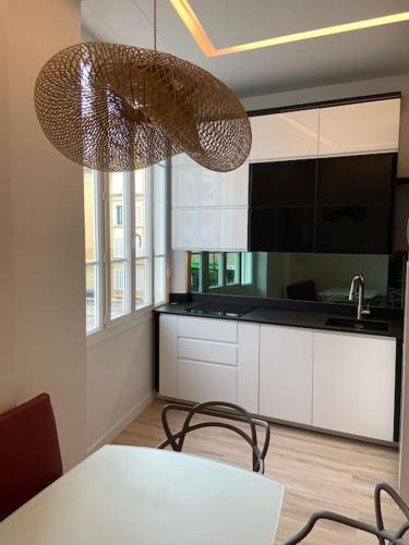 une cuisine avec une table et des chaises ainsi qu'un lustre dans l'établissement Riviera Beach, Design apartement near Croisette, à Cannes