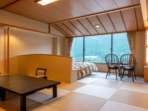 a room with a bed and a table and chairs at Sasara in Gero