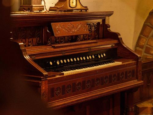 an old piano with a clock on top of it at Sasara in Gero