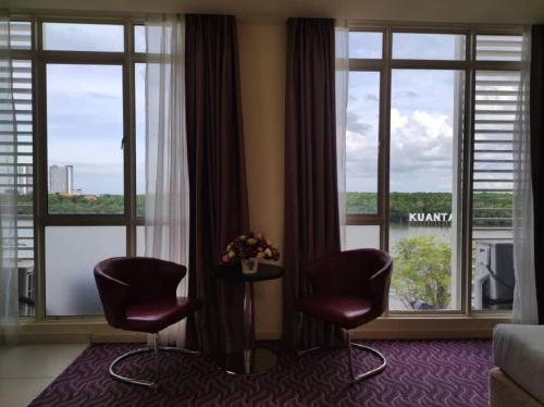 a hotel room with two chairs and a window at Hotel Sentral Kuantan @ Riverview City Centre in Kuantan