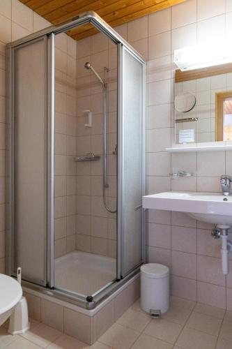 a bathroom with a shower and a toilet and a sink at Golf Hotel Des Alpes in Samedan