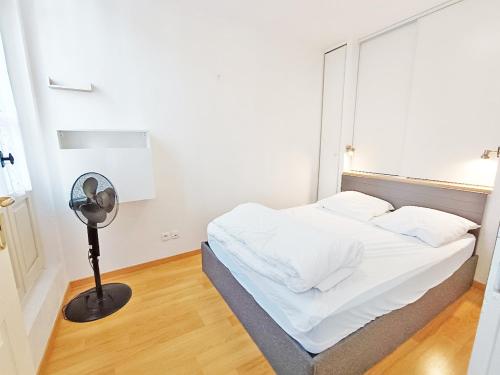 - une chambre avec un lit blanc et un ventilateur dans l'établissement Val Montalban, T2 wifi, 4 pers, ascenseur, casier à ski, à Luchon