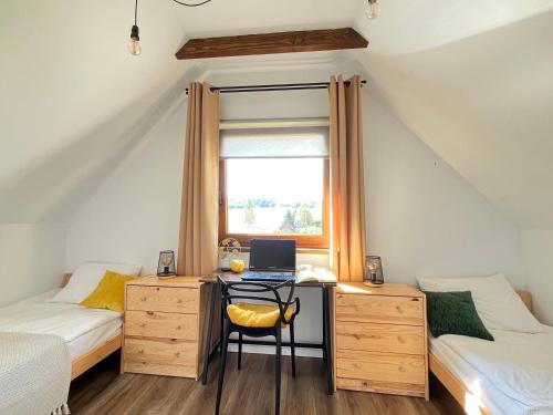 a bedroom with a desk with a laptop computer on it at Domki nad rzeką- Smerekowiec in Smerekowiec
