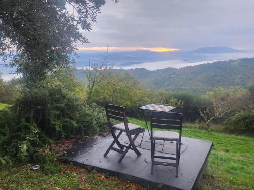 two chairs and a table with a view of a mountain at Alto Locandieri in Montebagnolo