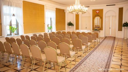 a row of chairs in a room with a chandelier at Hotel Zamek Pułtusk Dom Polonii in Pultusk