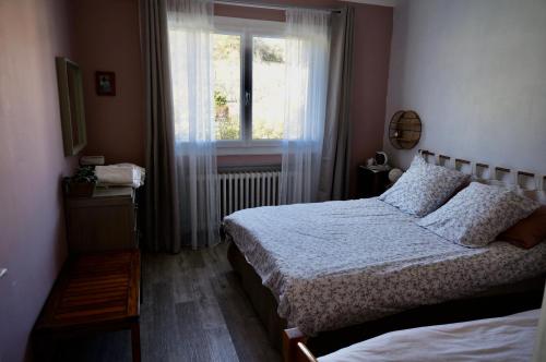une chambre avec deux lits et une fenêtre dans l'établissement la villa provençale, à La Motte-Chalançon