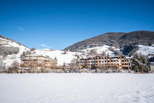 a resort in the mountains with a snow covered field at Dolomiten Residenz - Sporthotel Sillian in Sillian
