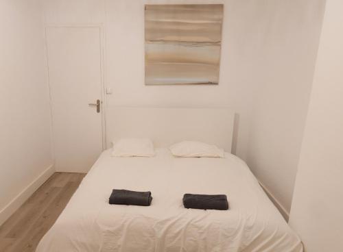 - un lit blanc avec 2 serviettes noires dans l'établissement Le Fongate, à Marseille