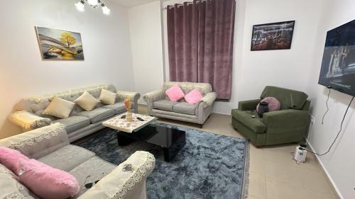 a living room with couches and chairs and a table at City Tower in Ajman 