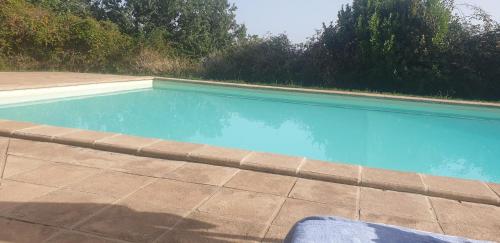 a swimming pool with blue water in a backyard at Alto Locandieri in Montebagnolo