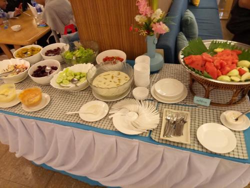 a table topped with plates and bowls of fruit at Bay Hotel Srinakarin in Bangna