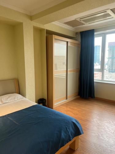 a bedroom with a bed and a large window at Lovely 2 BR unit with city view in Ulaanbaatar