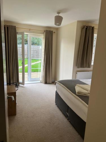 a bedroom with a bed and a sliding glass door at YBC Court, Aldershot in Aldershot