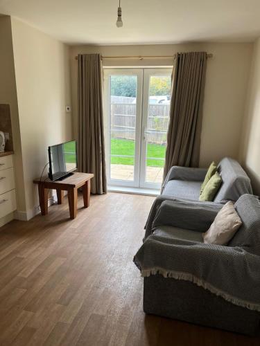 a living room with a bed and a tv and a window at YBC Court, Aldershot in Aldershot