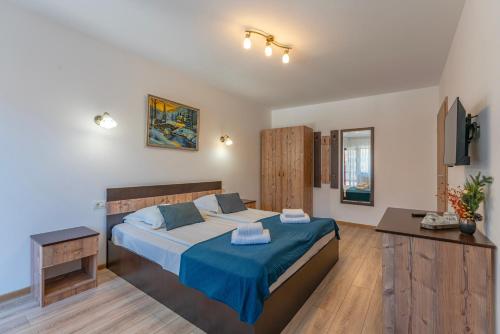 a bedroom with a large bed with a blue blanket at Rare Forest Retreat & Spa- Bran in Bran