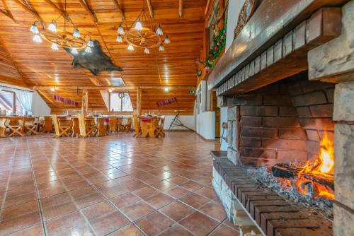 Una gran sala con una chimenea de ladrillo y una mesa. en Rare Forest Retreat & Spa, en Bran