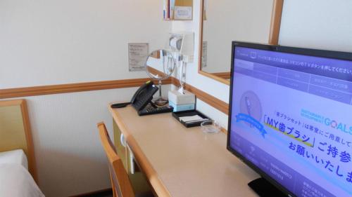 a desk with a computer monitor and a lamp on it at Toyoko Inn Shin-yamaguchi-eki Shinkansen-guchi in Yamaguchi