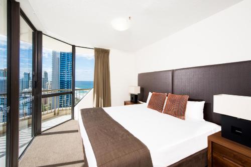 une chambre avec un grand lit et un balcon dans l'établissement Paradise Centre Apartments, à Gold Coast