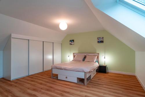 - une chambre avec un lit et un plafond voûté dans l'établissement La Villa de l'Odet - 4 Chambres et parking privé, à Pleuven