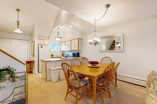 a kitchen and dining room with a wooden table and chairs at The Woods - Village-40 in Killington
