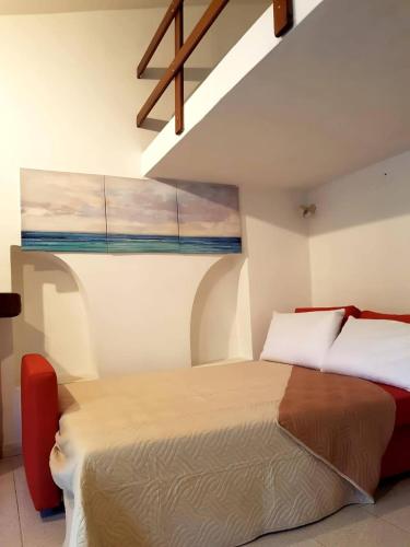 a bedroom with a bed and a window at Monolocale con veranda e giardino a Rio Marina in Rio Marina