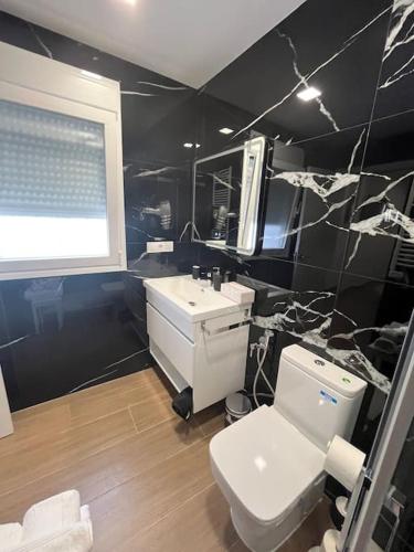 a bathroom with a white toilet and a sink at Apartamento Barajas Mercurio A in Madrid