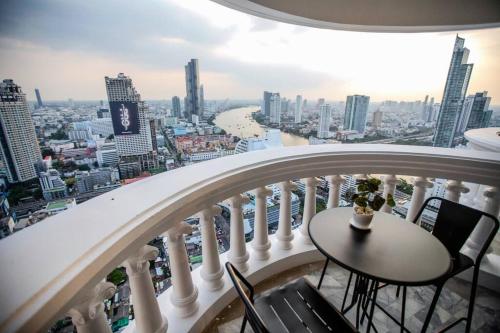 a balcony with a table and chairs and a city at Best river view - Loft apartment in great location in Bangkok