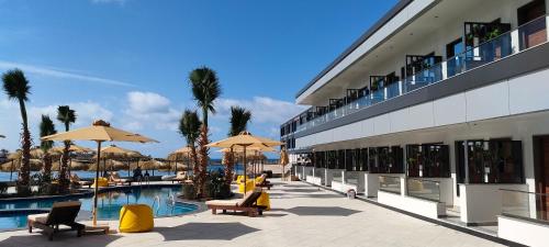a resort with a swimming pool and chairs and umbrellas at XU San Stefano Hotel Alexandria in Alexandria