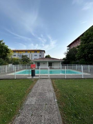 une piscine avec une clôture en face d'un bâtiment dans l'établissement cosy T2, 3pers, 2 lits, parking privée, wifi, à Agen