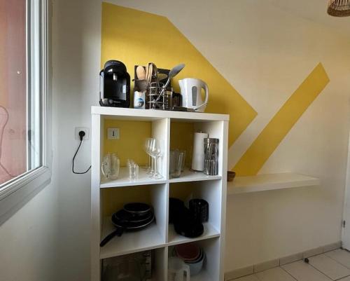 une étagère blanche avec des articles dans une pièce dans l'établissement cosy T2, 3pers, 2 lits, parking privée, wifi, à Agen