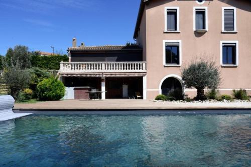 une maison avec une piscine devant une maison dans l'établissement Le Clos Saint Jean, vue Cité, piscine et parking, à Carcassonne