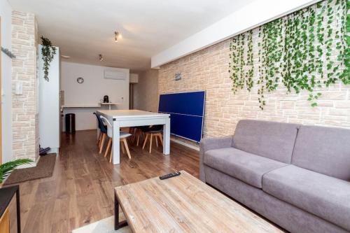 un salon avec un canapé et une table dans l'établissement L'appart Gaming du 36 - Clim,Jardin&Barbecue, à Joeuf