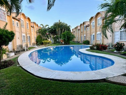 a swimming pool in the middle of a yard with a building at Hermosa Casa Con Alberca AC in Ixtapa