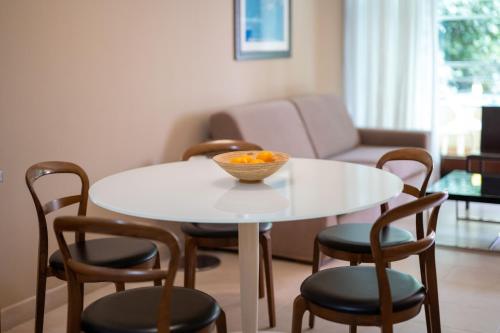 a white table with chairs and a bowl of oranges on it at The Residence Aparthotel in Podstrana
