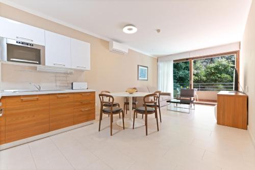 a kitchen and dining room with a table and chairs at The Residence Aparthotel in Podstrana