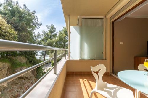 a room with a balcony with a table and chairs at The Residence Aparthotel in Podstrana